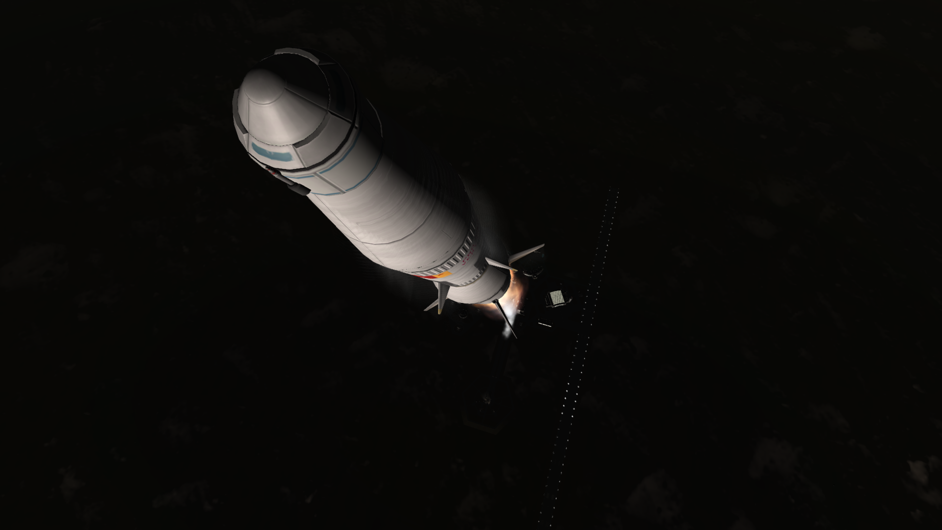 A view looking down the side of the rocket at the space center below, the long runway most evident.