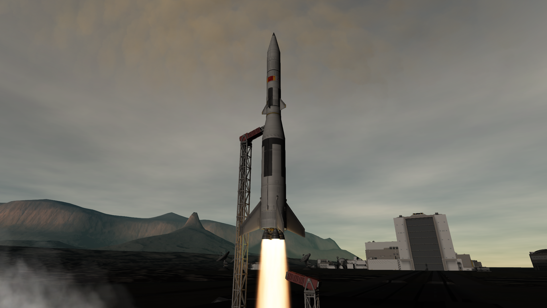 A third elongated rocket, this one with a slightly shorter nosecone, leaves the pad behind.